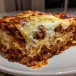 A thick, cheesy slice of homemade lasagna with rich meat sauce and bubbly cheese topping.