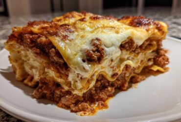 A thick, cheesy slice of homemade lasagna with rich meat sauce and bubbly cheese topping.