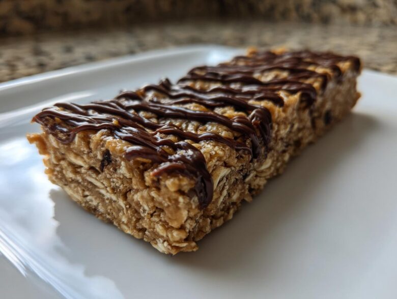 Close-up of a homemade protein bar made with oats and drizzled with melted chocolate.