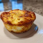 A single, perfectly baked cottage cheese egg cups starbucks style muffin on a white plate.