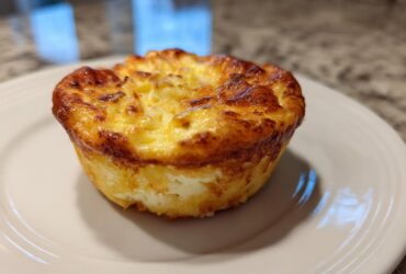 A single, perfectly baked cottage cheese egg cups starbucks style muffin on a white plate.