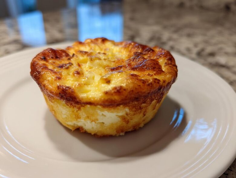 A single, perfectly baked cottage cheese egg cups starbucks style muffin on a white plate.
