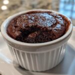 Close-up of a warm Cottage Cheese Microwave Brownie with a molten center served in a white fluted ramekin.