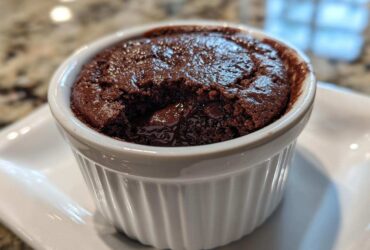 Close-up of a warm Cottage Cheese Microwave Brownie with a molten center served in a white fluted ramekin.