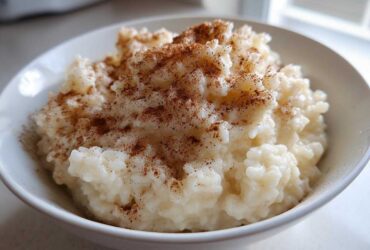Close-up of a bowl of creamy rice pudding generously sprinkled with ground cinnamon.