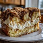 A thick slice of overnight french toast casserole with cream cheese filling and brown sugar crumble topping.