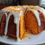 Close-up of a slice cut from a moist sweet potato pound cake drizzled with white icing.