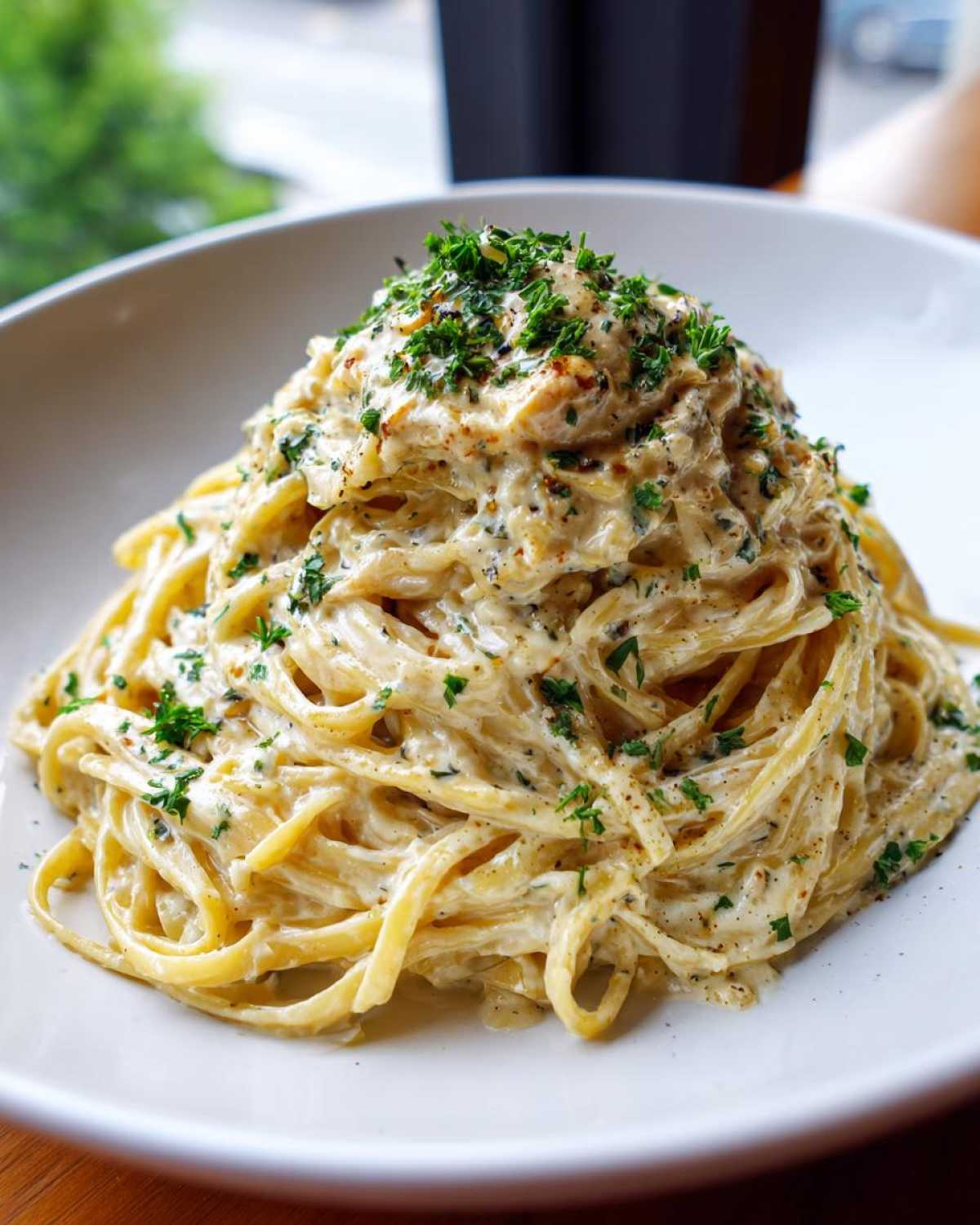 A close-up of creamy 1-Pot garlic parmesan pasta tossed in a rich sauce and topped with fresh parsley.