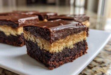 A single, thick square of buckeye brownies showing the fudgy chocolate base, peanut butter layer, and chocolate topping.