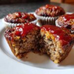 Cross-section view showing the moist, textured interior of an amazing mini meatloaf topped with shiny ketchup glaze.