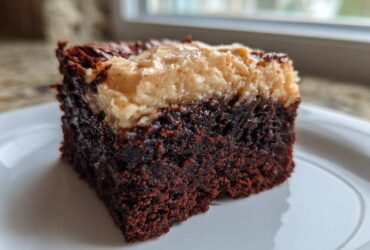 A close-up of a rich, dark chocolate banana bread brownies square topped with a lighter banana swirl.