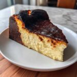 A perfectly baked slice of Basque burnt cheesecake with a dark, caramelized top.