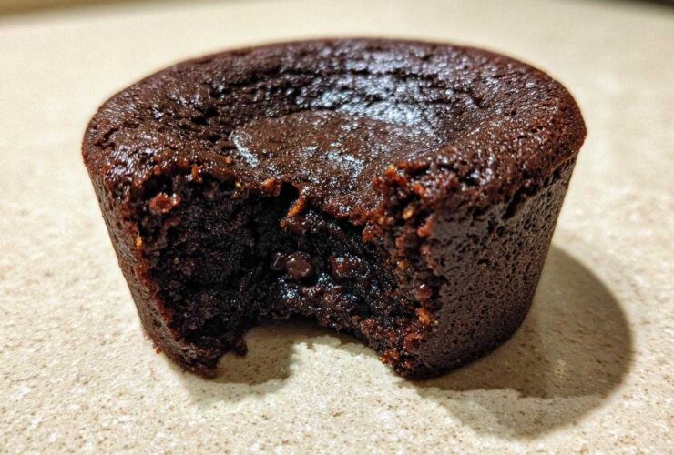 Close-up of a rich, dark chocolate Cottage Cheese Microwave Brownie with a bite taken out, showing a fudgy interior.