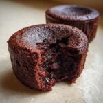 Close-up of a warm Cottage Cheese Microwave Brownie with a bite taken out, revealing a molten, gooey chocolate center.