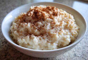 Close-up of a creamy bowl of homemade rice pudding generously topped with ground cinnamon.