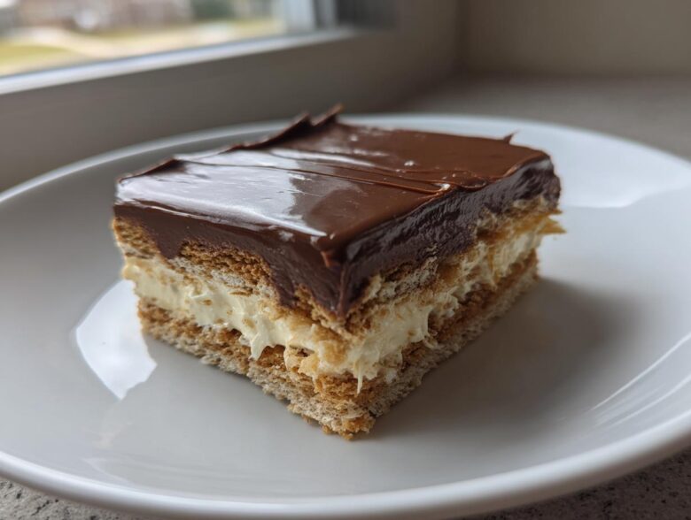 A single serving slice of an amazing 15-minute eclair cake featuring layers of graham crackers, cream filling, and chocolate frosting.