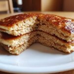 Close-up of fluffy almond flour pancakes stacked and cut in half, showing the light, airy interior texture.