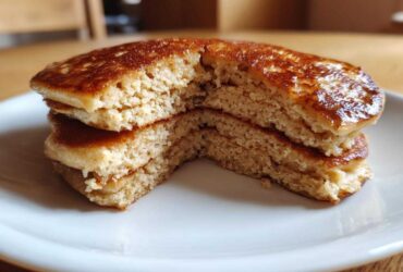 Close-up of fluffy almond flour pancakes stacked and cut in half, showing the light, airy interior texture.
