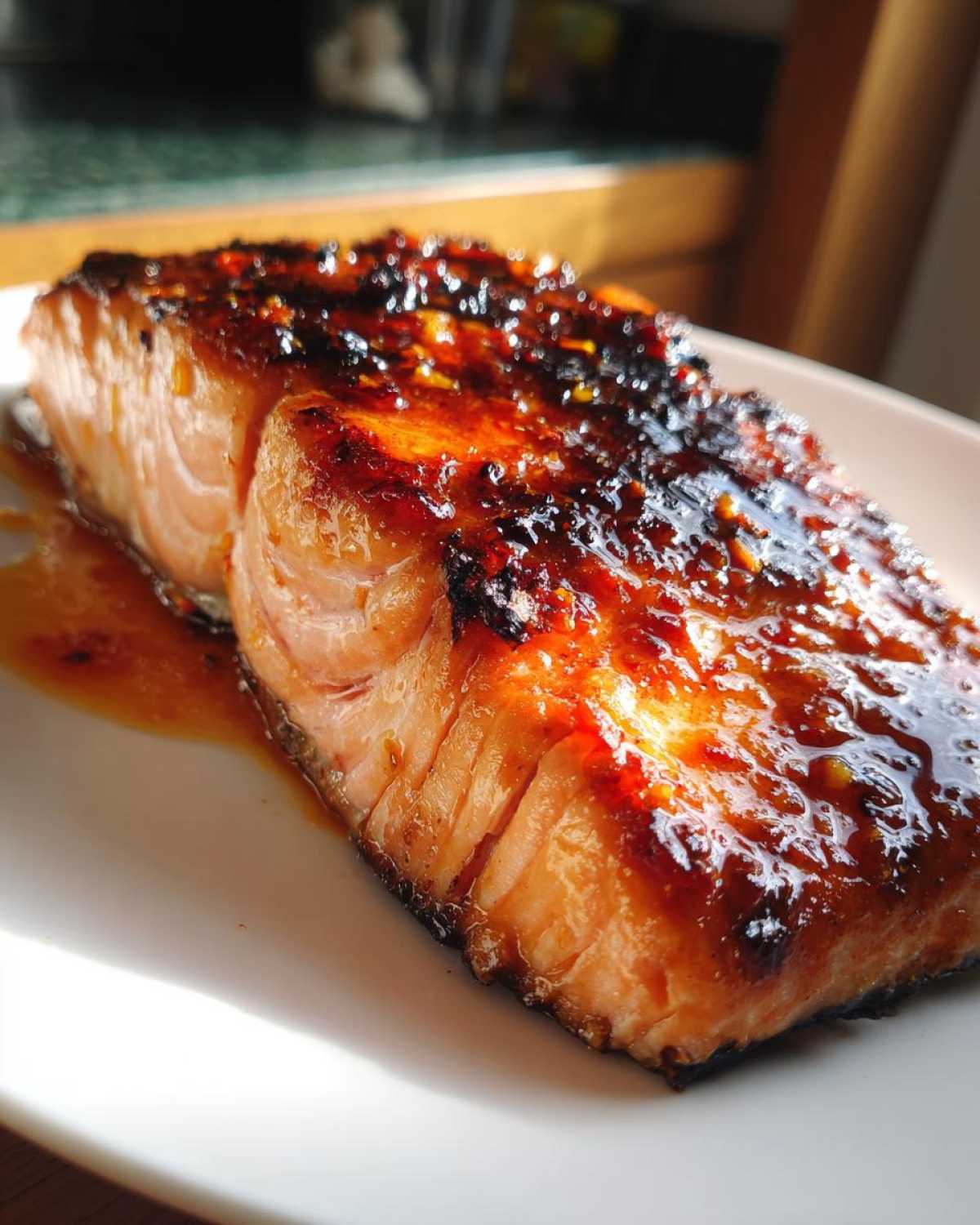 Close-up of a perfectly cooked salmon recipe fillet glazed with sticky honey garlic sauce.
