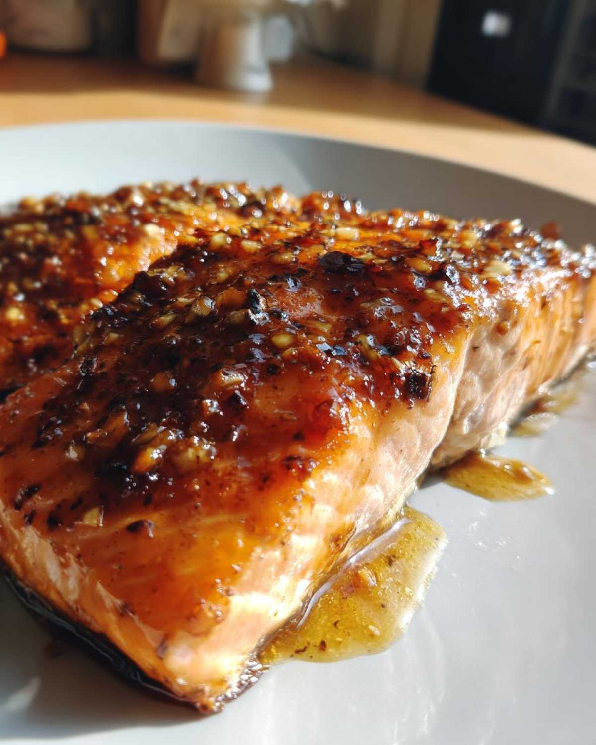 Close-up of a perfectly cooked salmon recipe fillet covered in a thick, shiny honey garlic glaze.