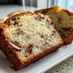 Close-up of moist slices of sweet alabama pecan bread showing pecans baked into the crumb.