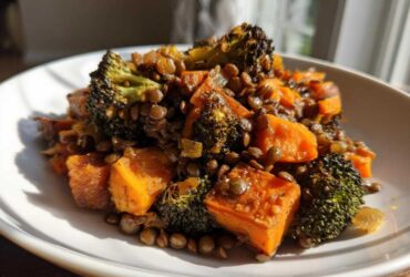 Close-up of a serving of veggie lentil salad featuring roasted sweet potatoes, dark green lentils, and charred broccoli florets.