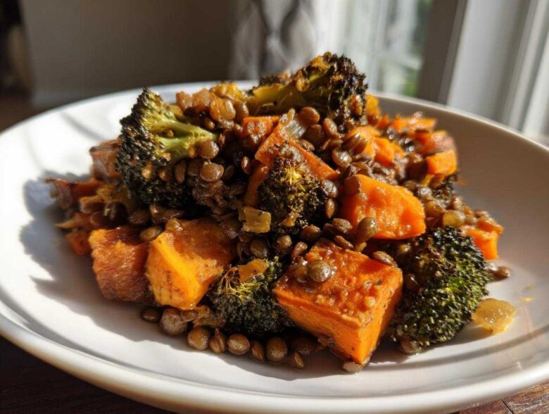 Close-up of a serving of veggie lentil salad featuring roasted sweet potatoes, dark green lentils, and charred broccoli florets.