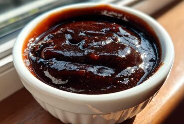 Close-up of thick, dark Copycat Chick-fil-A Honey Roasted BBQ Sauce in a white ramekin.