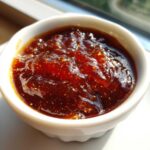 Close-up of thick, glossy Copycat Chick-fil-A Honey Roasted BBQ Sauce in a small white ramekin.