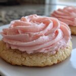 Close-up of a thick, soft Copycat Crumbl Sugar Cookie with Pink Frosting piped in a rose swirl.