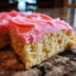 A close-up slice of a soft, yellow sugar cookie base topped with thick, bright pink frosting, resembling a Copycat Crumbl Sugar Cookie with Pink Frosting.