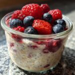 Close-up of Easy Berry Chia Overnight Oats topped with fresh strawberries, blueberries, and raspberries.