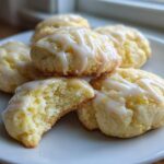 A stack of soft Gluten-Free Lemon Ricotta Cookies drizzled with white lemon icing, one cookie broken open to show the texture.