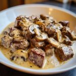 Close-up of tender beef cubes and sliced mushrooms coated in a creamy sauce in Instant Pot Beef Stroganoff with Mushrooms.