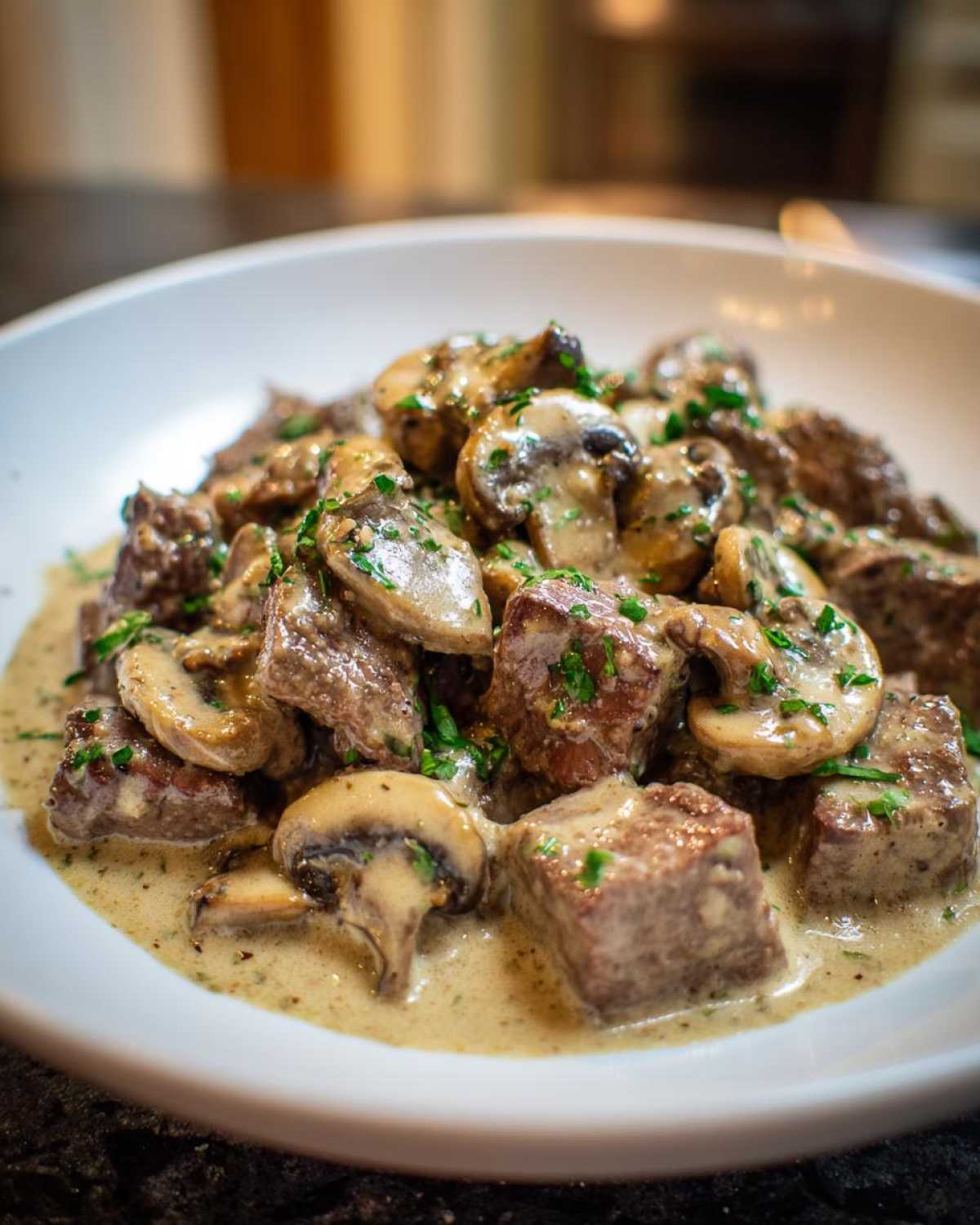 Close-up of tender beef cubes and sliced mushrooms coated in creamy sauce for Instant Pot Beef Stroganoff with Mushrooms.