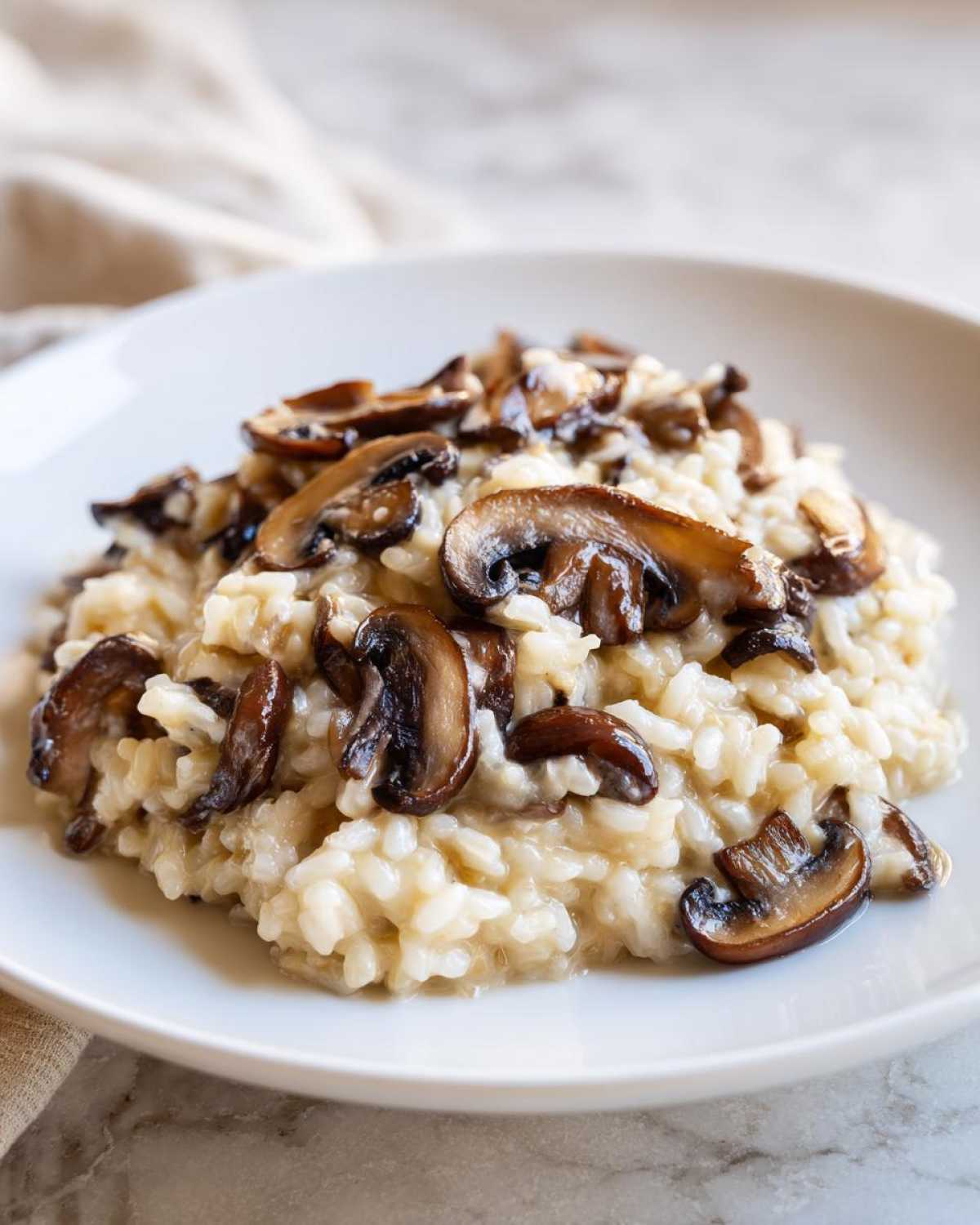 Close-up of creamy Instant Pot Creamy Mushroom Risotto topped with sautéed brown mushrooms.