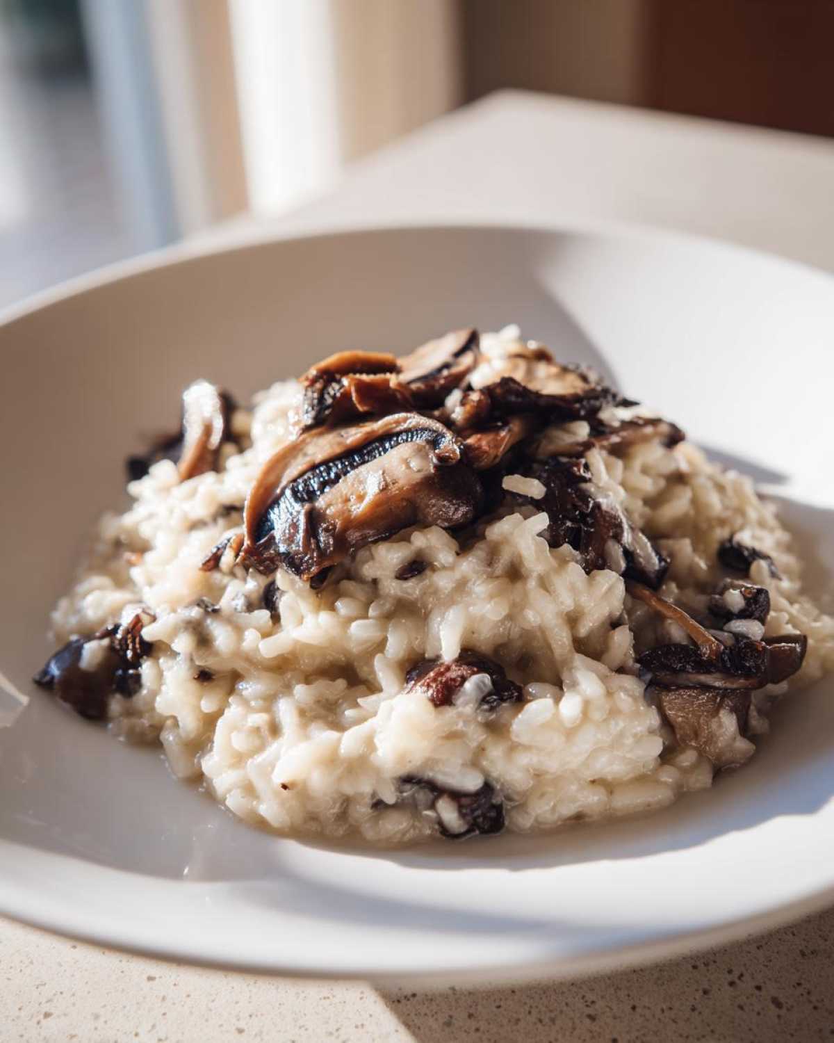 Close-up of a serving of Instant Pot Creamy Mushroom Risotto topped with sautéed sliced mushrooms.