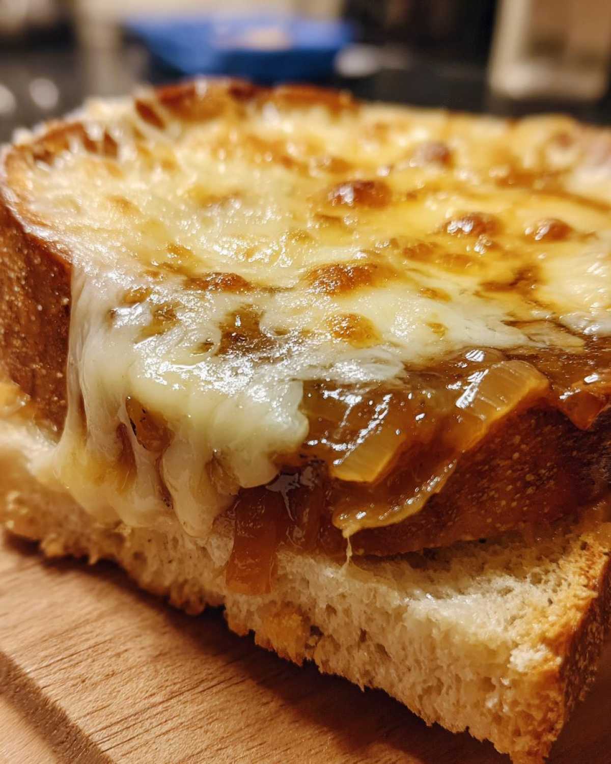 Close-up of toasted bread topped with caramelized onions and melted, browned cheese from Instant Pot French Onion Soup.