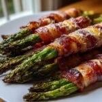 Close-up of perfectly cooked Keto Bacon Wrapped Asparagus Bundles, featuring crispy bacon and melted cheese.