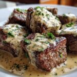 Close-up of seared Keto Creamy Peppercorn Steak Bites smothered in a rich, creamy sauce and garnished with parsley.