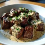 Close-up of seared steak bites smothered in creamy peppercorn sauce and garnished with parsley, perfect Keto Creamy Peppercorn Steak Bites.