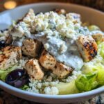 Close-up of Keto Greek Chicken Bowls featuring grilled chicken, cauliflower rice, olives, and tzatziki sauce.