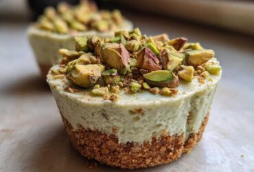 A close-up of a No-Bake Pistachio Cheesecake Cup with a graham cracker crust and topped generously with chopped pistachios.