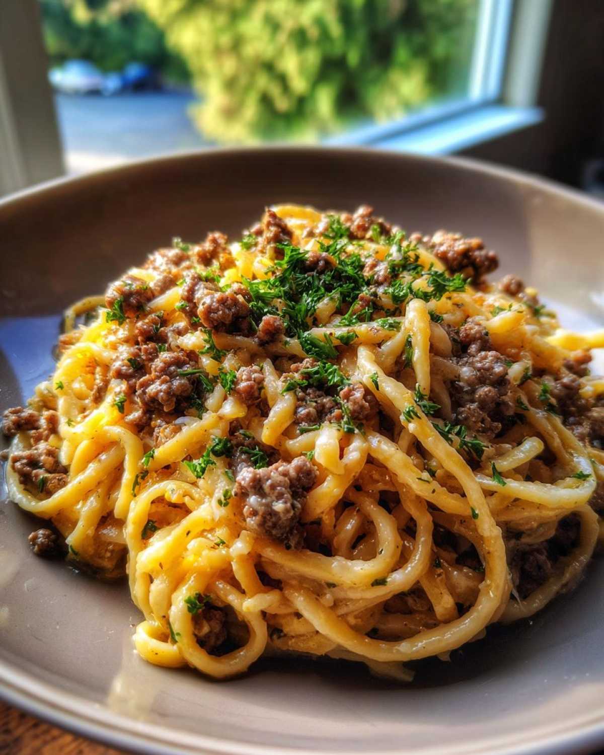 A close-up of One-Pot Creamy Garlic Butter Beef and Noodles topped with fresh parsley.