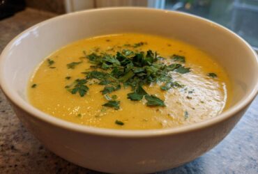 Close-up of a bowl of Vegan Creamy Lemon Garlic White Bean Soup garnished with fresh parsley.