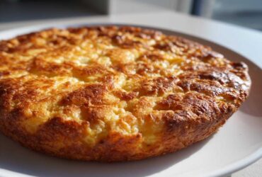Close-up of a perfectly baked, golden brown 4-ingredient keto pizza crust resting on a white plate.