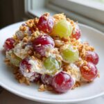A close-up of creamy chicken salad chick grape salad mixed with a creamy dressing and topped with crunchy brown crumbs.
