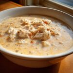 Close-up of a bowl of creamy crab soup generously topped with large flakes of white crab meat.