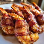 Close-up of several perfectly cooked, crispy bacon wrapped shrimp with glazed, caramelized bacon.