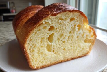 Close-up of a freshly baked japanese milk bread loaf, showing its soft, yellow, and airy interior crumb.